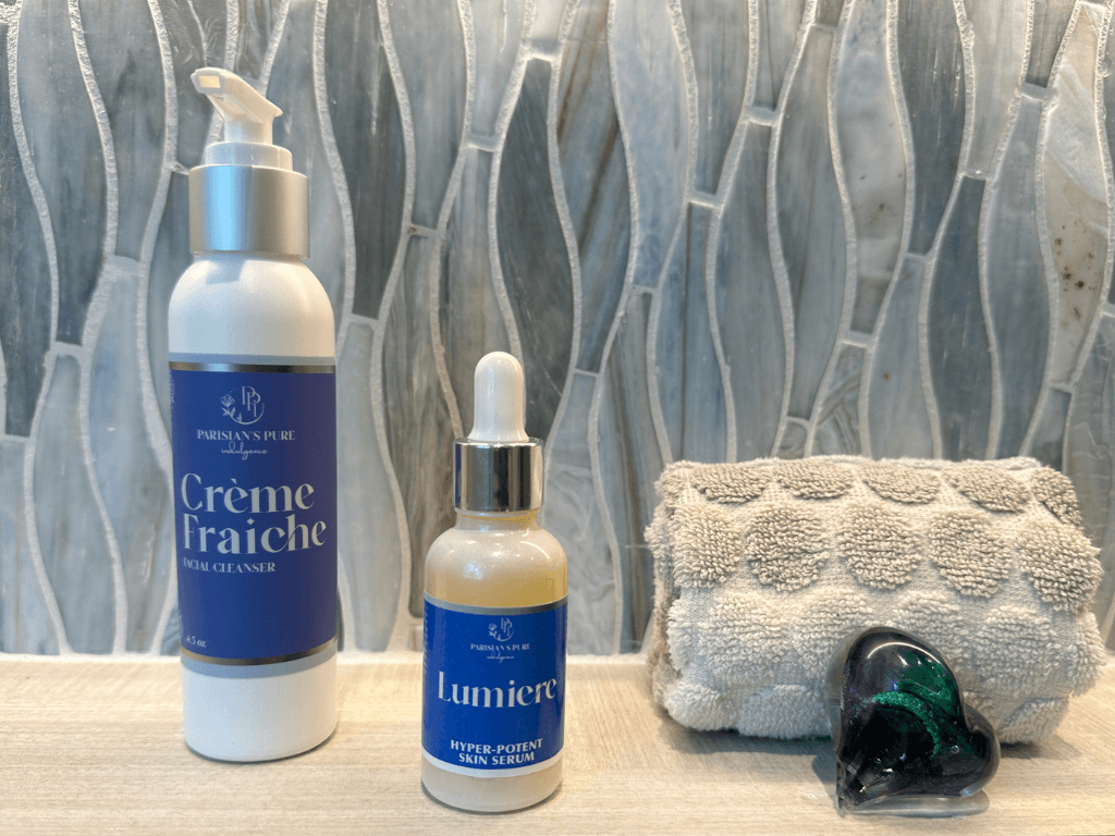 Creme Fraiche Face Cleanser and Lumiere Hyper Serum with washcloth in bathroom setting