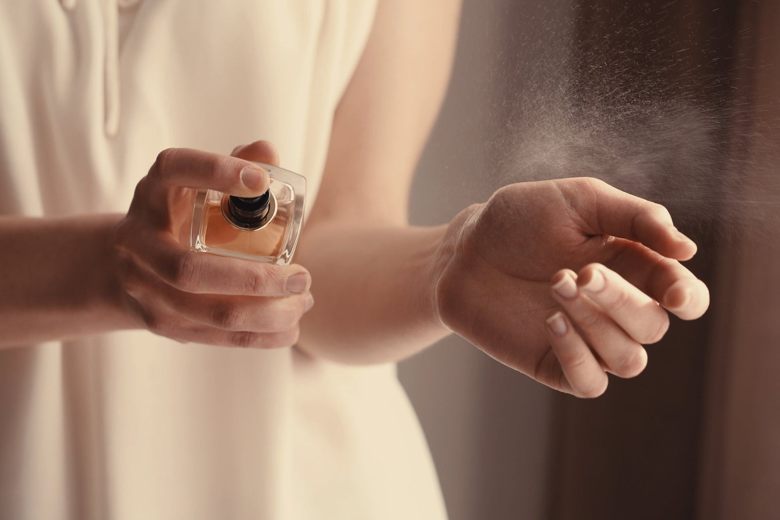 Woman spraying perfume on wrist | Unscented Truths: Decoding Fragrance as a Modern Health Irritant