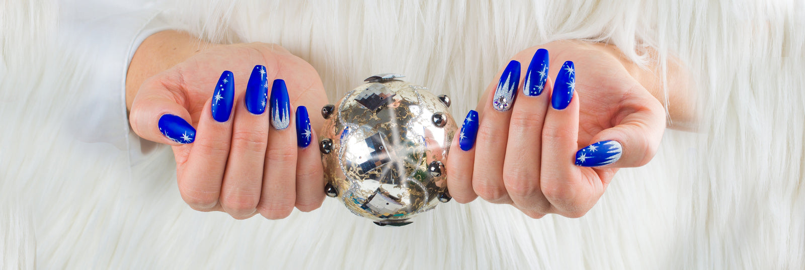 Womans hands with blue coffin shaped nails and silver ornament | Trends in nail shapes and lengths