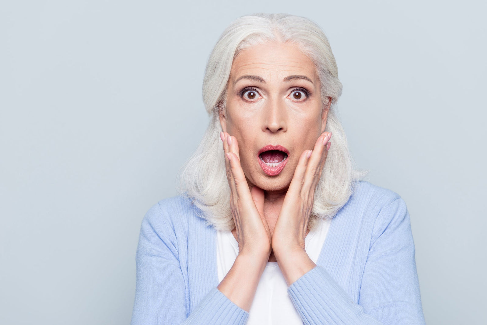 Mature Woman looking surprised with hands on face