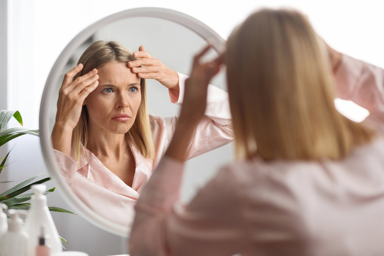 Woman looking in a mirror at her skin issues | Parisians Pure | The Top 5 Age-related skin issues and how to fix them