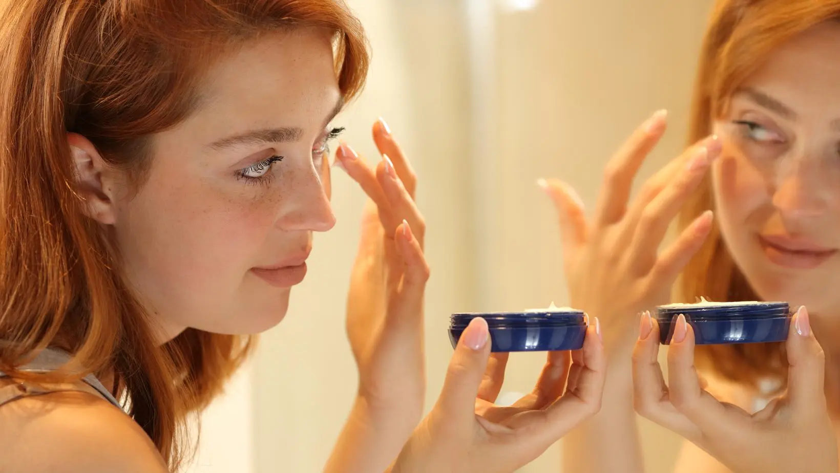 Woman looking into mirror and applying eye cream | Unlock-the-Secrets-Your-Guide-to-Choosing-the-Ideal-Eye-Cream-for-Radiant-and-Youthful-Eyes | Parisians Pure Indulgence