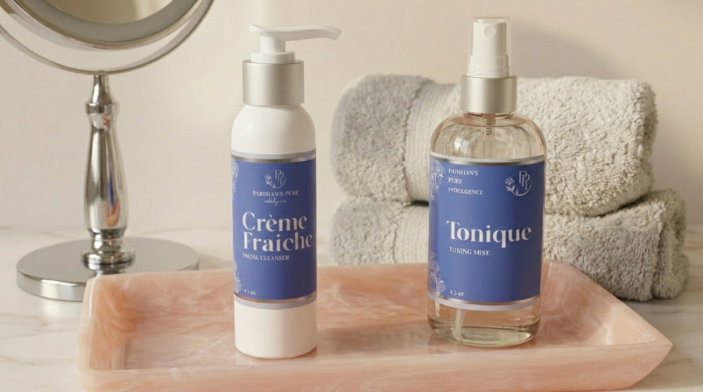 Two skincare products, 'Creme Fraiche' and 'Tonique', on a tray with towels and a mirror in the background.