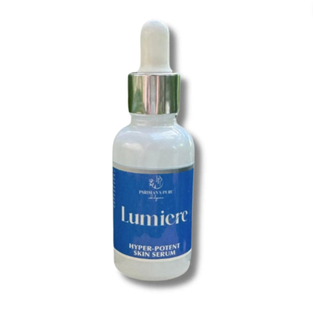 Bottle of Lumiere organic anti-aging serum with dropper for mature skin being held in hand with greenery behind
