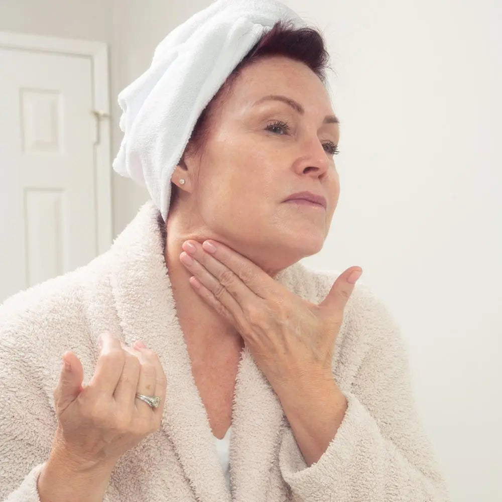 Woman applying sun protecting Parasol SPF 50 to neck | Parasol SPF 50 Daily Moisturizer: Broad Spectrum Sun Protection | Parisians Pure