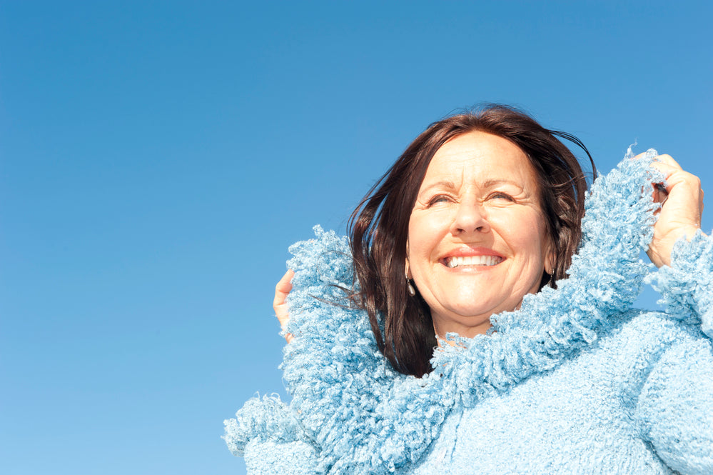 vibant, happy, brunette woman over 50 outside wearing blue | Parisians Pure Indulgence