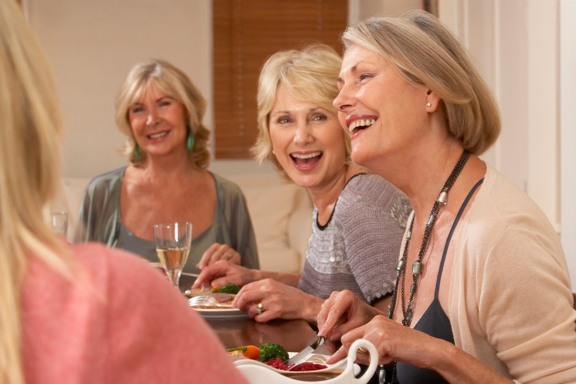 Three women in chic and cozy Thanksgiving outfits