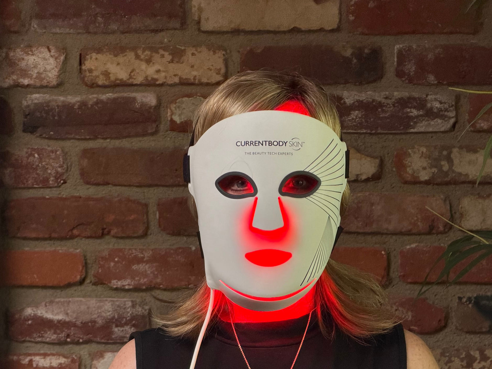 Kelli wearing a red light therapy mask